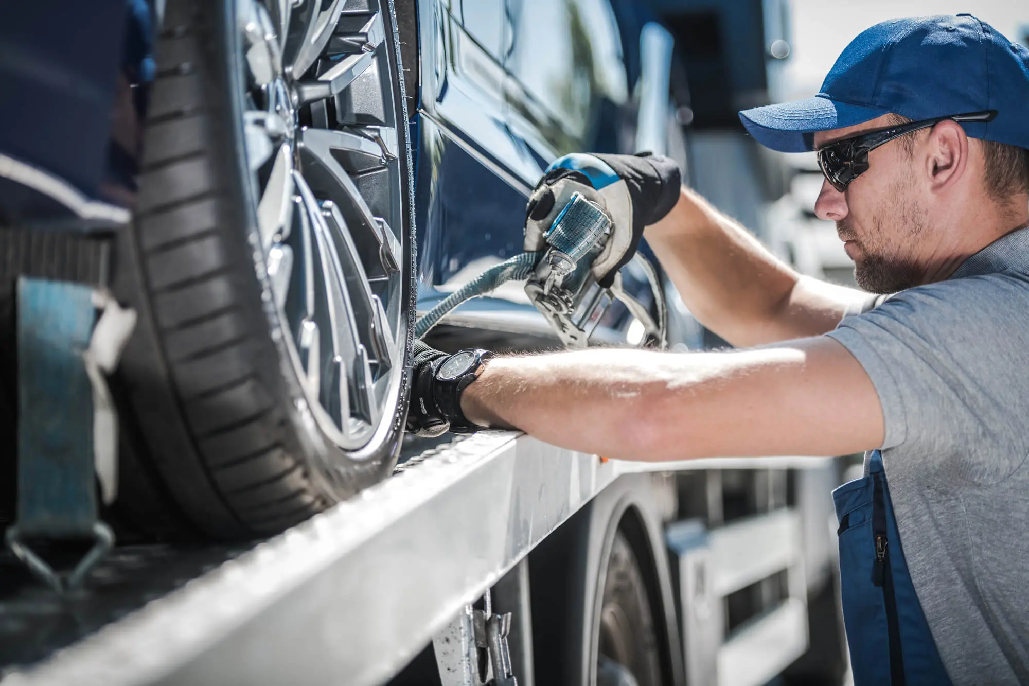 Worker securing vehicle on tow truck in bright day 2026 03 25 09 22 19 utc.jpg